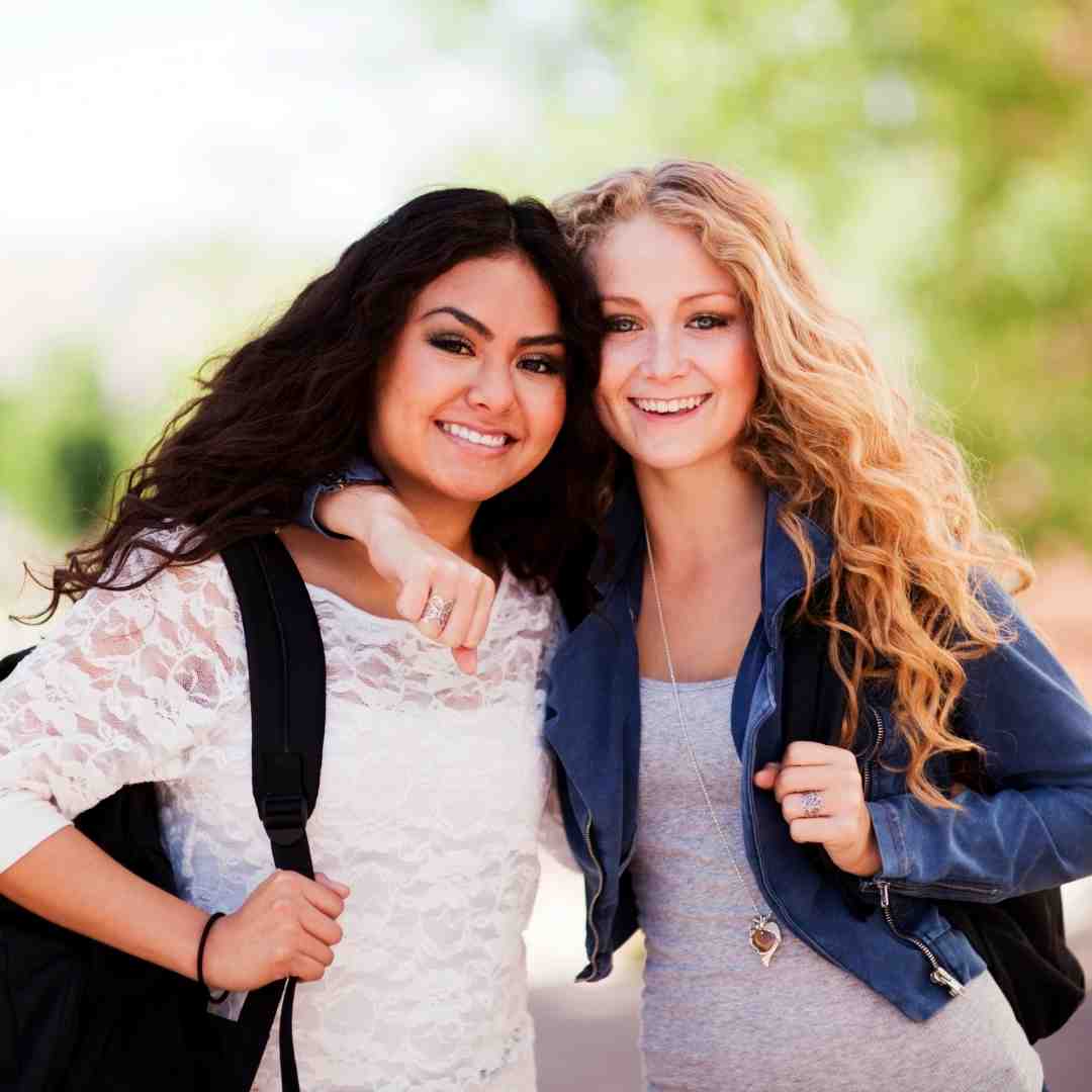 Two college friends smiling.