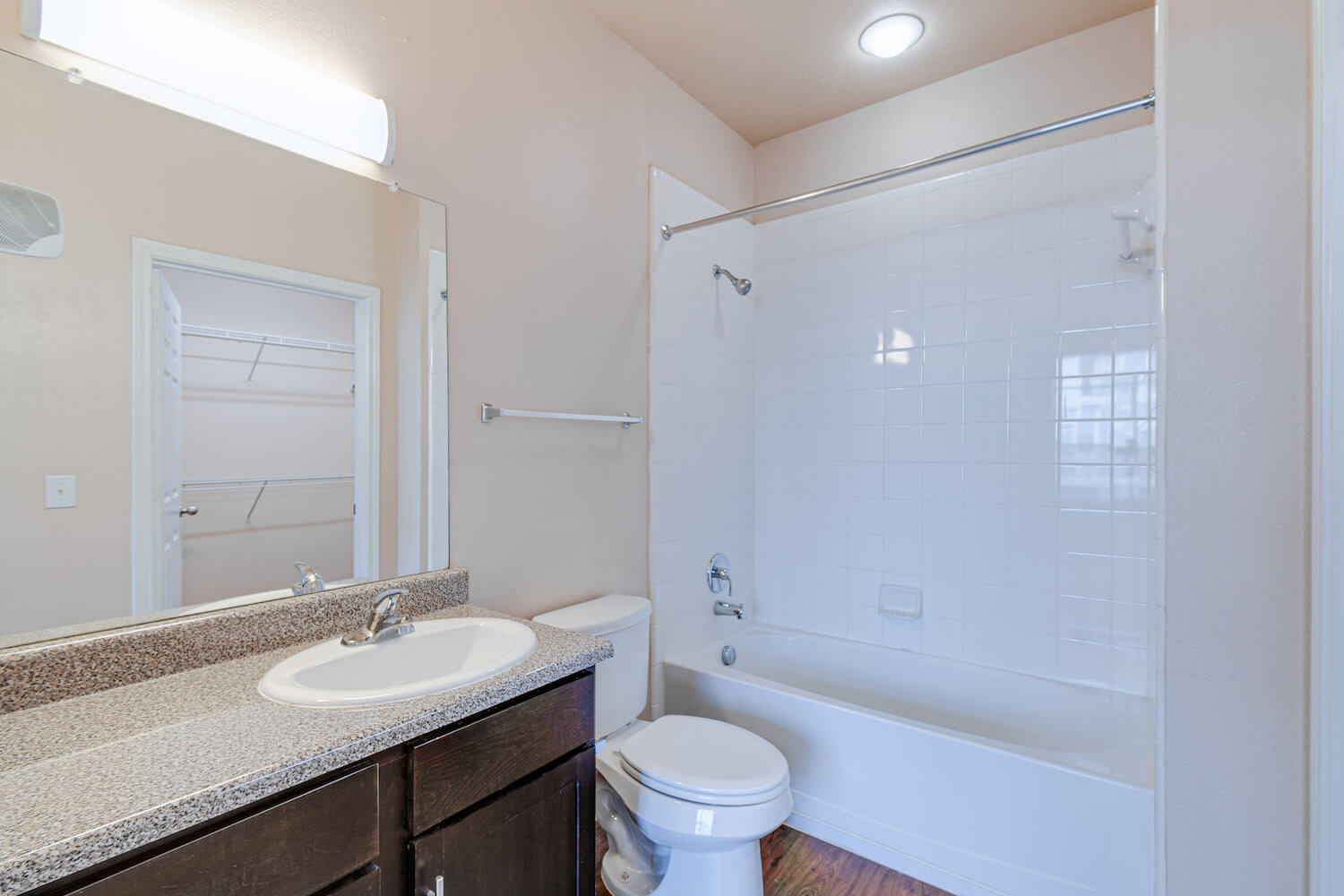 A brightly-lit bathroom with dark cabinets.