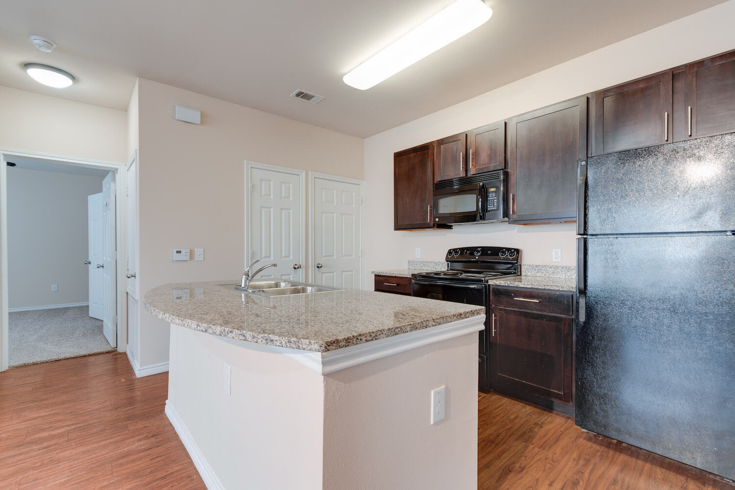 The kitchen with all appliances and a granite counter top overlooking the living area.