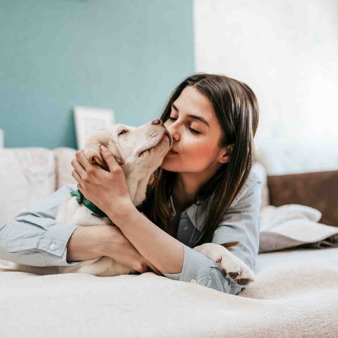 A woman cuddling her dog.