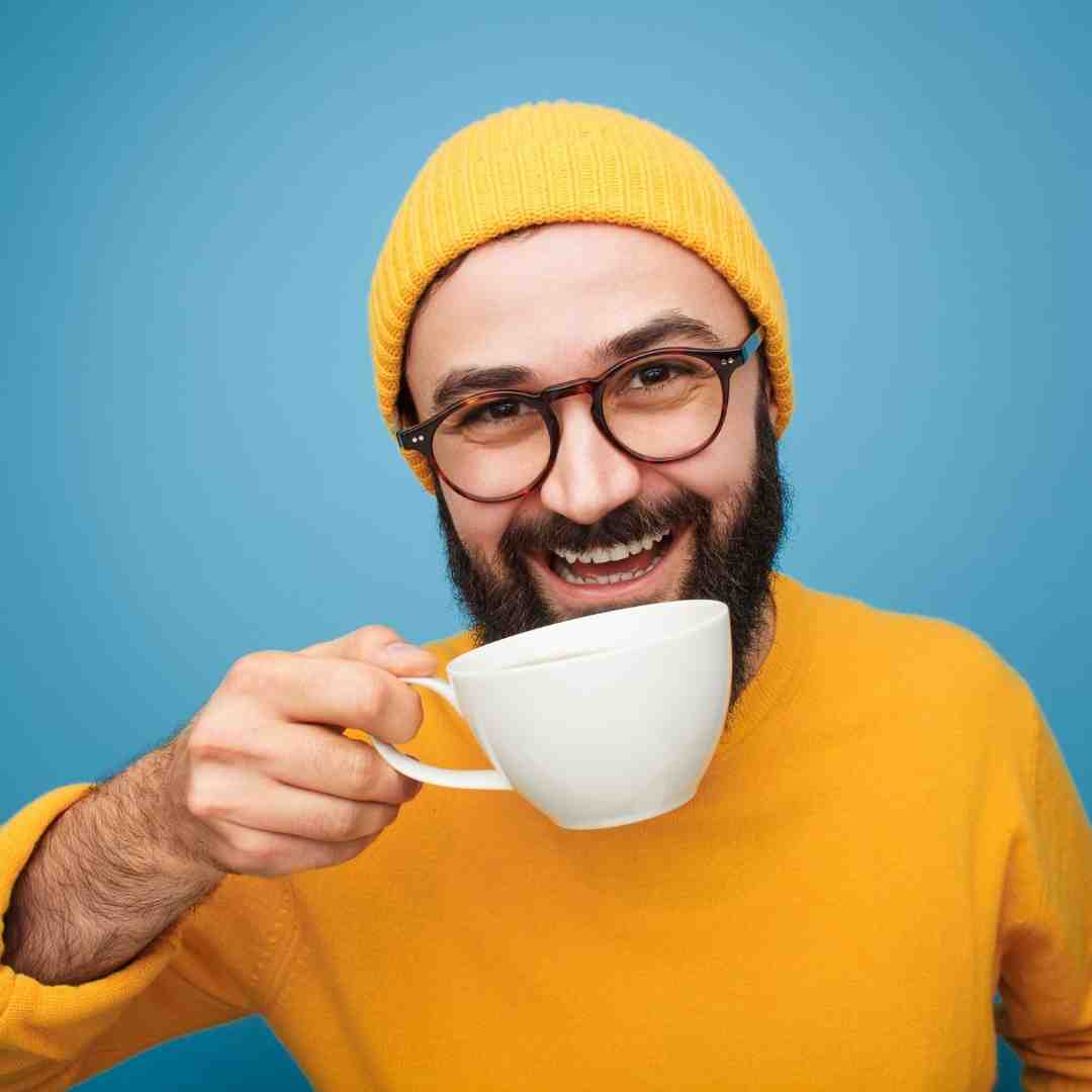 A happy man drinking a cup of coffee.